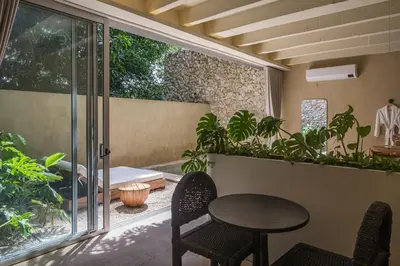 a patio with a table and chairs and plants at Arde La Selva in Santa Fe de Antioquia