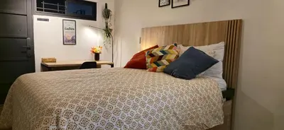 a bedroom with a bed with a wooden headboard and pillows at Apartamento Envigado wifi 700 mb in Envigado