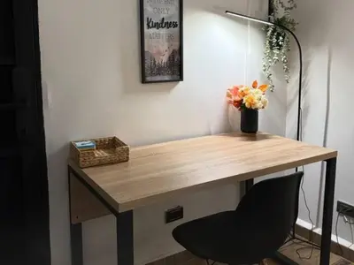 a desk with a chair and a vase of flowers at Apartamento Envigado wifi 700 mb in Envigado