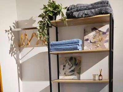 a shelf with towels and a plant on it at Apartamento Envigado wifi 700 mb in Envigado