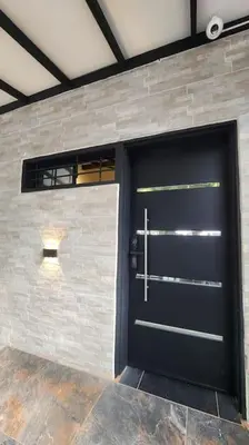 a garage with a black door and a brick wall at Apartamento Envigado wifi 700 mb in Envigado