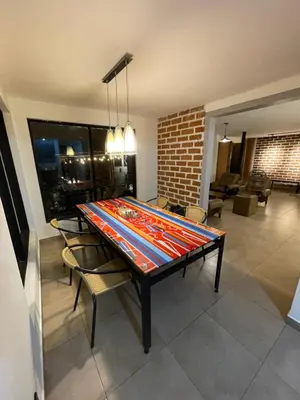 a dining room table with chairs and a brick wall at Casa de Campo completa ubicada en Santa Elena in Santa Elena