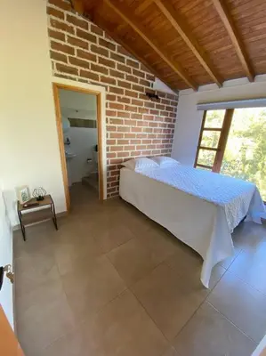 a bedroom with a bed and a brick wall at Casa de Campo completa ubicada en Santa Elena in Santa Elena