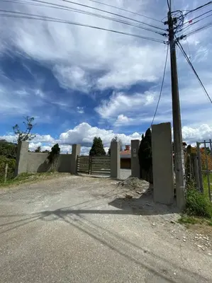 a fence and a road with a gate and sky at Casa de Campo completa ubicada en Santa Elena in Santa Elena