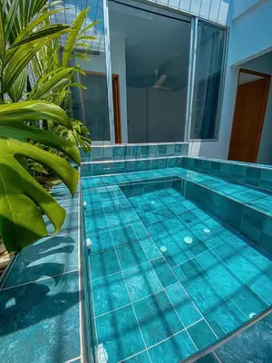 a swimming pool with blue tiles on the floor at Casa de Verano Altos de la Colina-Doradal in Doradal