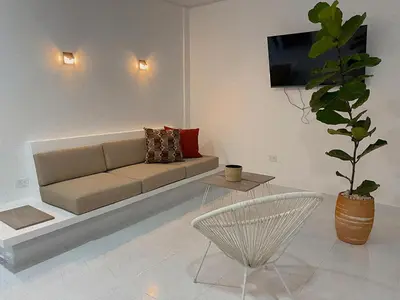 a living room with a couch and a potted plant at Casa de Verano Altos de la Colina-Doradal in Doradal