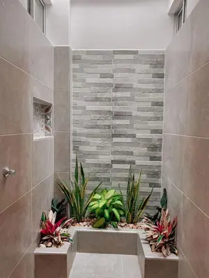 a bathroom with plants in the corner of a shower at Casa de Verano Altos de la Colina-Doradal in Doradal