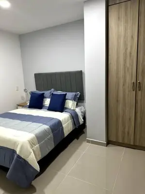 a bedroom with a large bed with blue pillows at Hermoso Apartamento Entero in Itagüí