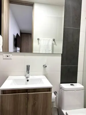 a bathroom with a sink and a toilet and a mirror at Hermoso Apartamento Entero in Itagüí