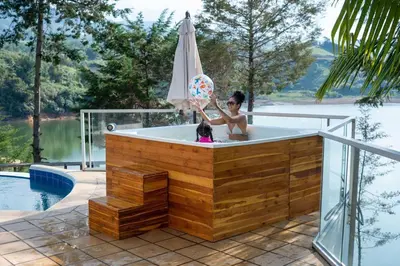 a girl in a hot tub with an umbrella at Casa de Campo PREMIUN in Guatapé
