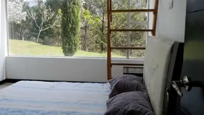 a bedroom with a bed in front of a window at Casa de Campo PREMIUN in Guatapé