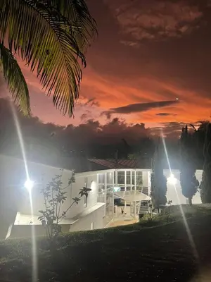 a house with a sunset in the background at Casa de Campo PREMIUN in Guatapé