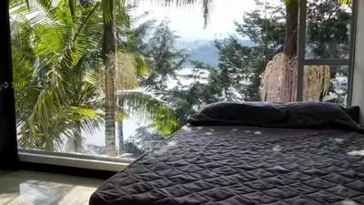 a bed in a room with a large window at Casa de Campo PREMIUN in Guatapé