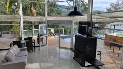 a living room with a tv and a large glass wall at Casa de Campo PREMIUN in Guatapé