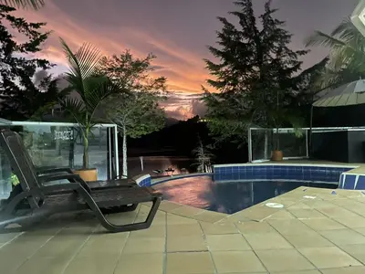 a chair sitting next to a swimming pool at Casa de Campo PREMIUN in Guatapé