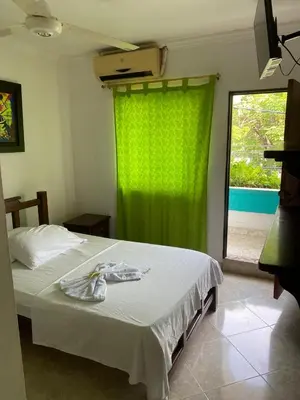 a bedroom with a bed with a green curtain at Hotel Boyaca in Puerto Boyacá