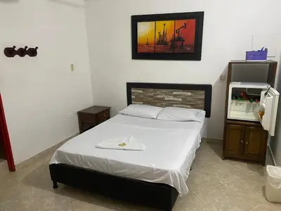 a bedroom with a bed and a picture on the wall at Hotel Boyaca in Puerto Boyacá