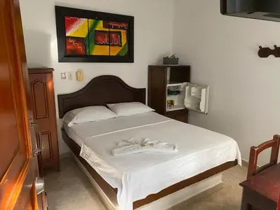 a bedroom with a bed with a white bedspread at Hotel Boyaca in Puerto Boyacá