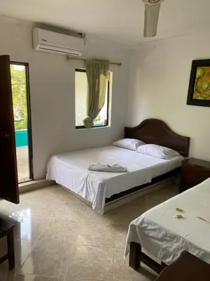 a bedroom with two beds and a window at Hotel Boyaca in Puerto Boyacá