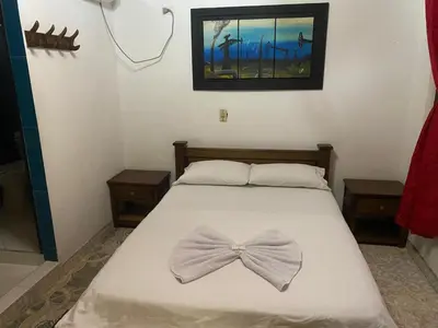 a bedroom with a bed with a bow tie on it at Hotel Boyaca in Puerto Boyacá