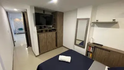 a small room with a bed and a television at Hermoso apartamento en Manizales in Manizales