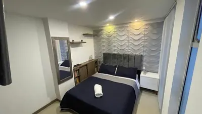 a small bedroom with a bed and a bath tub at Hermoso apartamento en Manizales in Manizales
