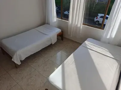 a small room with two beds and a window at Comodas y agradables Habitaciones en Chipre in Manizales