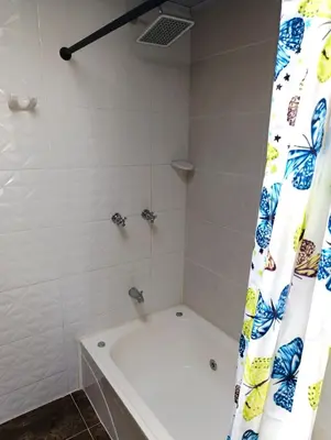a bathroom with a tub and a shower curtain at Comodas y agradables Habitaciones en Chipre in Manizales