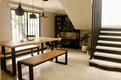 a living room with a table and a bench and stairs at Casa Primavera in El Poblado