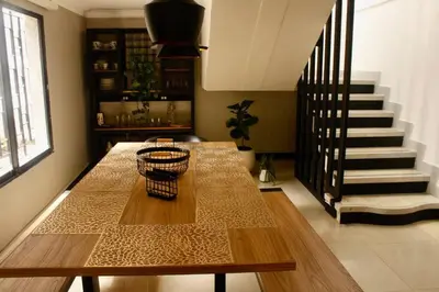 a dining room with a table and a staircase at Casa Primavera in El Poblado