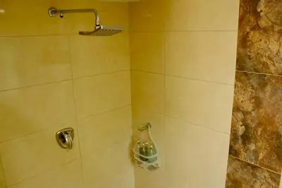 a bathroom with a shower with a bottle on the wall at Casa Primavera in El Poblado