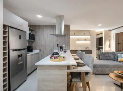 a kitchen and living room with a table and a couch at Apto nuevo, elegante y cómodo in Medellín