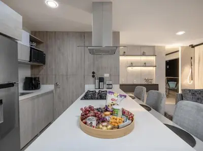 a kitchen with a table with a bowl of fruit on it at Apto nuevo, elegante y cómodo in Medellín