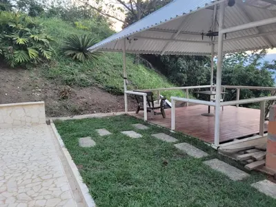 a wooden deck with a bench and an umbrella at Finca Familiar Talena in Sopetran
