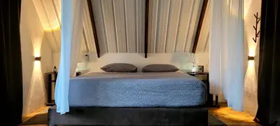 a bedroom with a bed with white curtains at Cómoda y acogedora cerca al Pueblo in Sopetran