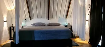 a bedroom with a bed with white curtains at Cómoda y acogedora cerca al Pueblo in Sopetran