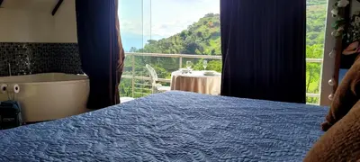 a bedroom with a bed and a view of a balcony at Cabaña en el Aire con jacuzzi a 5min del Pueblo in Sopetran