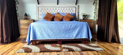 a bedroom with a bed with a blue comforter at Cabaña en el Aire con jacuzzi a 5min del Pueblo in Sopetran