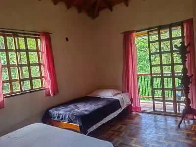 a bedroom with two beds and two windows at Ecohotel Otrolado Lodge in Los Andes