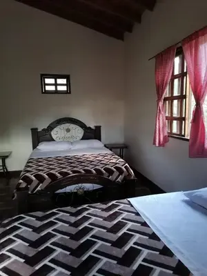 a bedroom with two beds and two windows at Ecohotel Otrolado Lodge in Los Andes