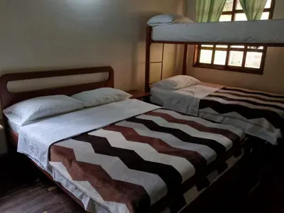 two beds sitting next to each other in a bedroom at Ecohotel Otrolado Lodge in Los Andes