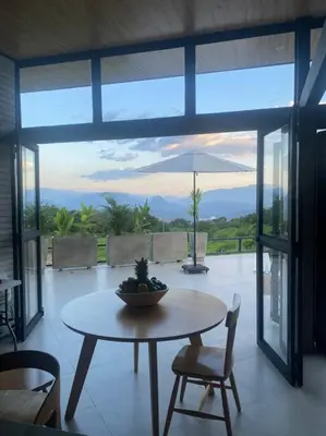 a table and chairs in a room with a view at Finca Calathea in Marsella