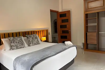 a bedroom with a large bed with a wooden headboard at Casa Palos Altos; Poblado; 6 min de Provenza; in El Poblado