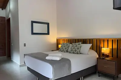 a bedroom with a large bed with a wooden headboard at Casa Palos Altos; Poblado; 6 min de Provenza; in El Poblado