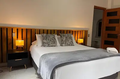 a bedroom with a large white bed with two lamps at Casa Palos Altos; Poblado; 6 min de Provenza; in El Poblado