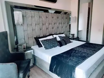 a bedroom with a large bed and a chair at Class suites nirvana in El Poblado