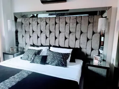 a bedroom with a bed with a large headboard at Class suites nirvana in El Poblado