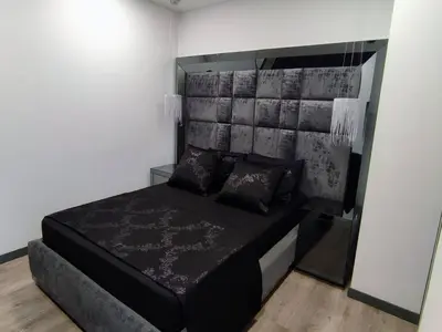 a bedroom with a black bed with a headboard at Class suites nirvana in El Poblado