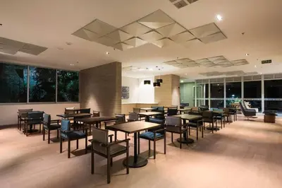 a dining room with tables and chairs and windows at Urban studios luxurious apartment in the poblado in Medellín