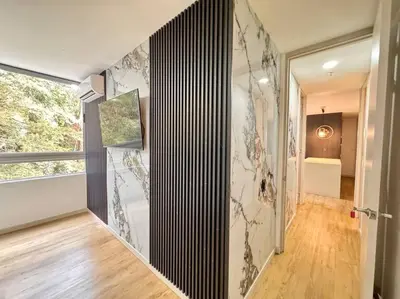 a room with a hallway with a wall with floral wallpaper at Urban studios luxurious apartment in the poblado in Medellín